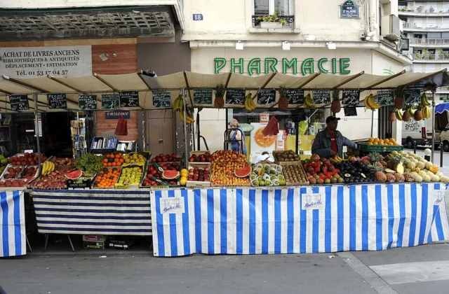 Fruit and vegetable stalls with striped awnings at Marché d’Aligre in Paris