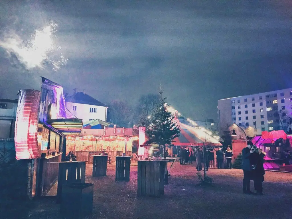 Märchenbazar Christmas Market in Munich with colorful tents, fairy lights, and festive atmosphere near Olympiapark, Germany.