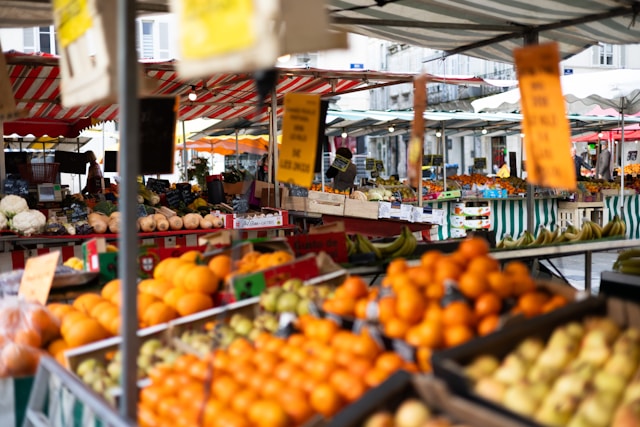 Fresh fruits and vegetables displayed at a local farmers market with colorful stalls and seasonal produce